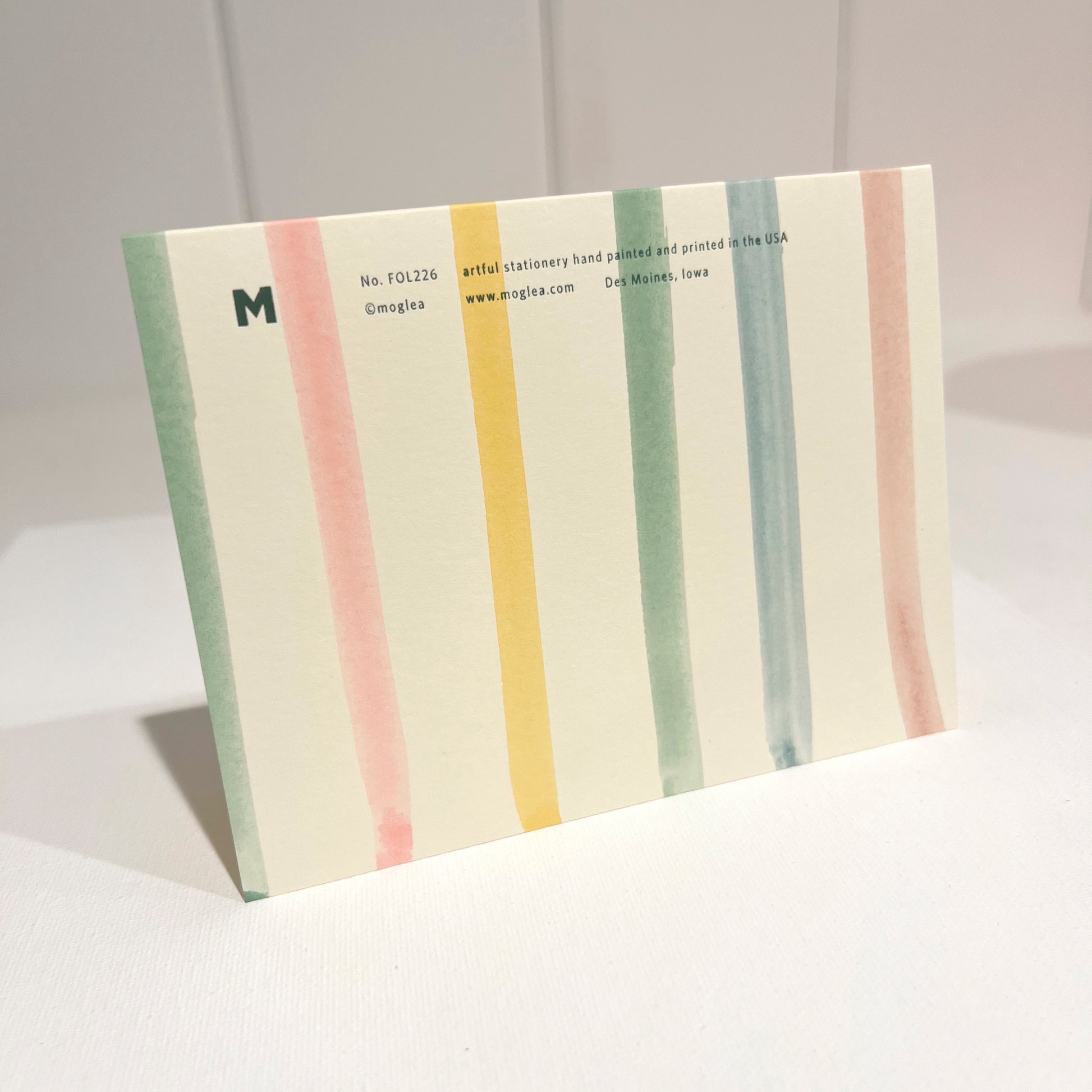 Pastel Stripe card with foil text on a light background with off white envelope.
Card standing upright on envelope.