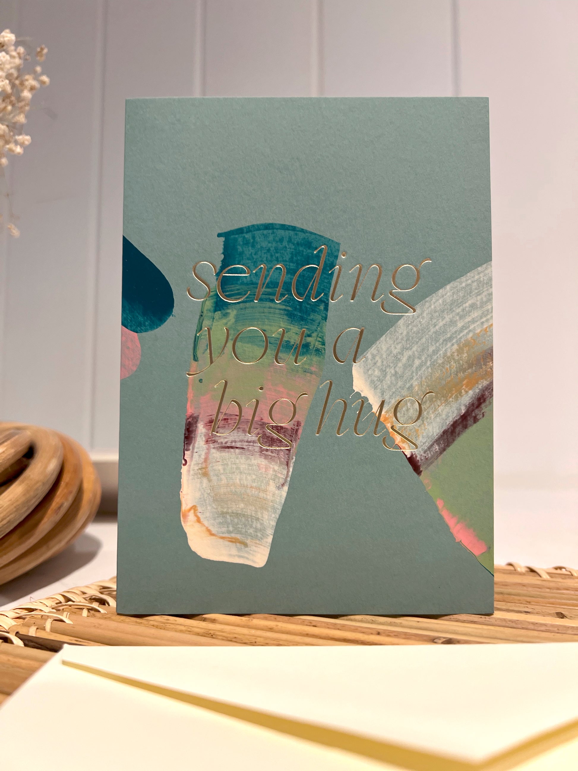 Moglea "sending you a big hug "card
Hand painted multicolor brush strokes folded card with color foil wording. Each card has a unique abstract design and color. Paired with an off white envelope.
FOLA605 big hug.
Styled on a rattan grass trivet.